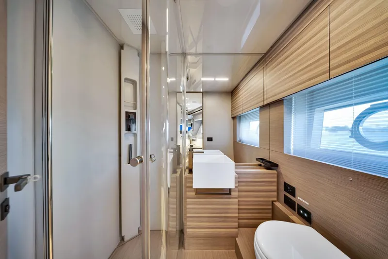 Yacht Photos Pics Luxurious bathroom interior of 2022 Ferretti Yachts 670 with modern wood finishes.