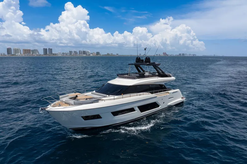  Yacht Photos Pics 2022 Ferretti Yachts 670 cruising on open sea with city skyline in background.