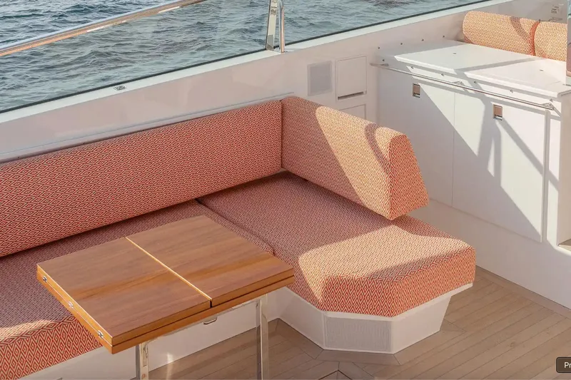  Yacht Photos Pics Luxurious seating area on 2024 Delta Powerboats 60 Open, featuring patterned cushions and wooden table.