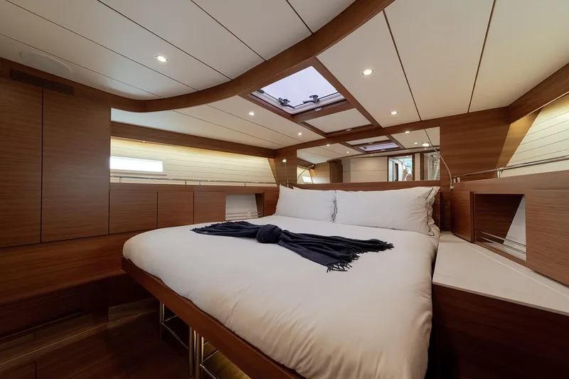  Yacht Photos Pics Luxurious cabin interior of 2024 Delta Powerboats 60 Open, featuring elegant wood finishes and cozy bedding.