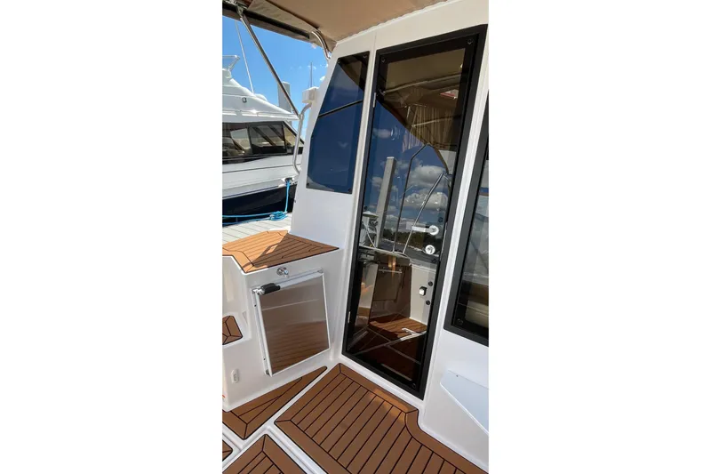  Yacht Photos Pics 2025 Ranger Tugs R-27 Seakeeper Ride boat deck with sleek design and wood accents.