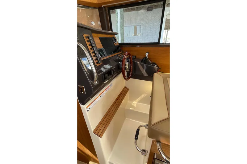  Yacht Photos Pics 2025 Ranger Tugs R-27 Seakeeper Ride helm with modern controls and wood accents.
