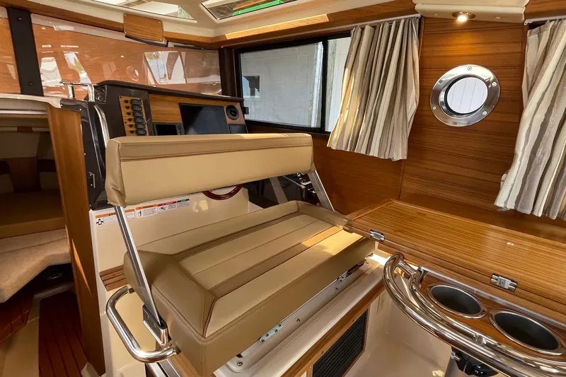  Yacht Photos Pics 2025 Ranger Tugs R-27 Seakeeper Ride interior with helm, seating, and wood paneling.
