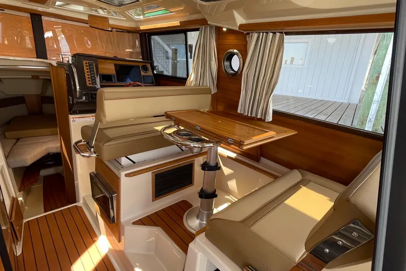  Yacht Photos Pics Interior of 2025 Ranger Tugs R-27 Seakeeper Ride, featuring elegant wood finishes and seating.