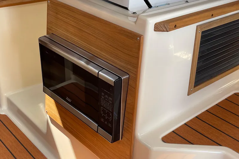  Yacht Photos Pics 2025 Ranger Tugs R-27 Seakeeper Ride interior with built-in microwave and wood accents.