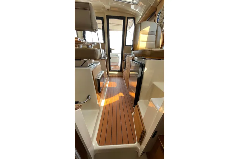  Yacht Photos Pics Interior of 2025 Ranger Tugs R-27 Seakeeper Ride, featuring elegant wood flooring and modern design.
