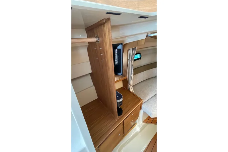  Yacht Photos Pics Interior of 2025 Ranger Tugs R-27 Seakeeper Ride, featuring wood cabinetry and cozy seating.