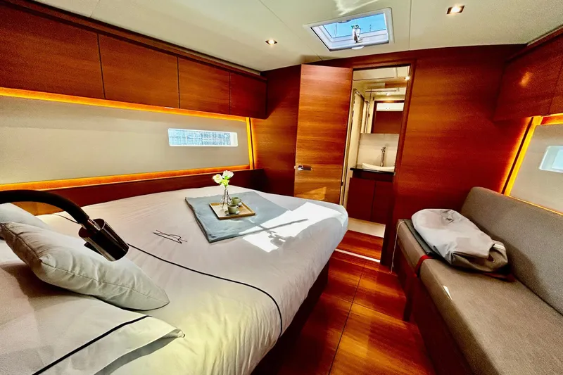 Nemo Yacht Photos Pics Luxurious interior of 2022 Solaris 55 yacht with elegant wood finishes and cozy bedding.