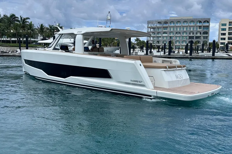 M2o Yacht Photos Pics 2024 Fjord 53 XL luxury yacht cruising in a marina with modern architecture.