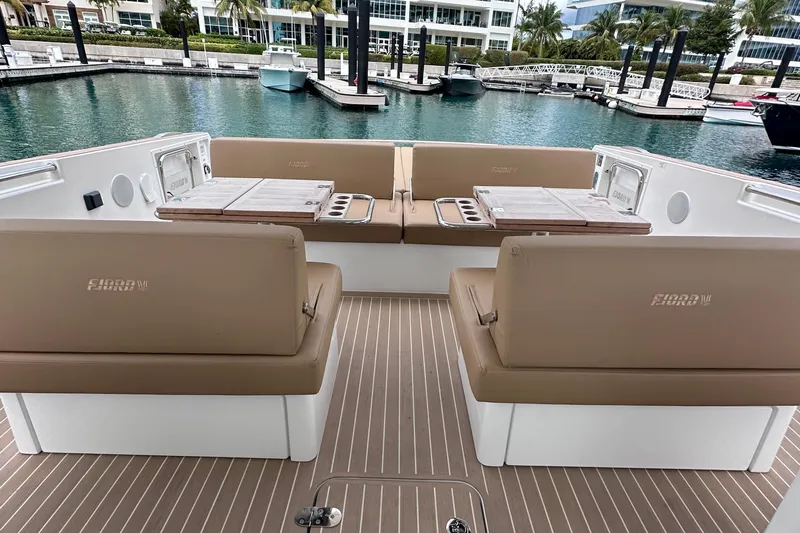 M2o Yacht Photos Pics 2024 Fjord 53 XL yacht interior with beige seating and wooden tables at a marina.