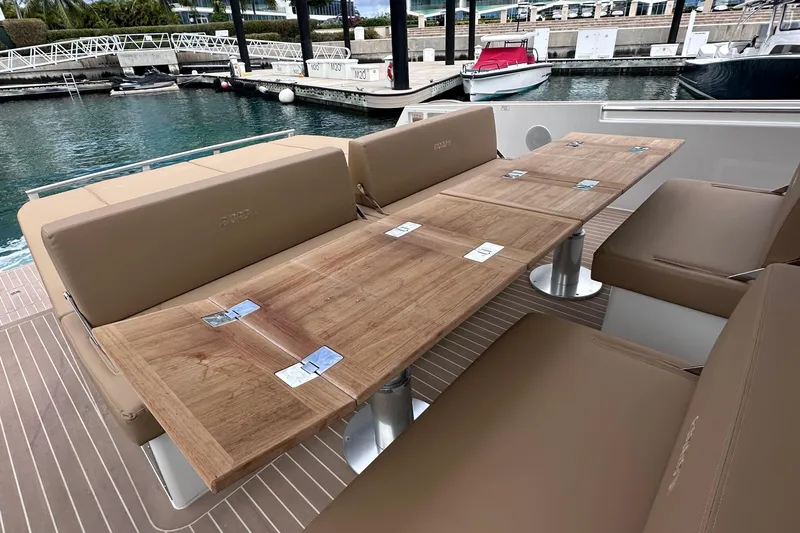 M2o Yacht Photos Pics Luxurious seating area on 2024 Fjord 53 XL yacht with wooden table and beige cushions.
