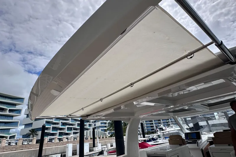 M2o Yacht Photos Pics 2024 Fjord 53 XL yacht with retractable sunshade, docked near modern buildings.