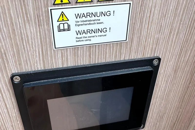 M2o Yacht Photos Pics Warning sign and screen on 2024 Fjord 53 XL, advising manual consultation before use.