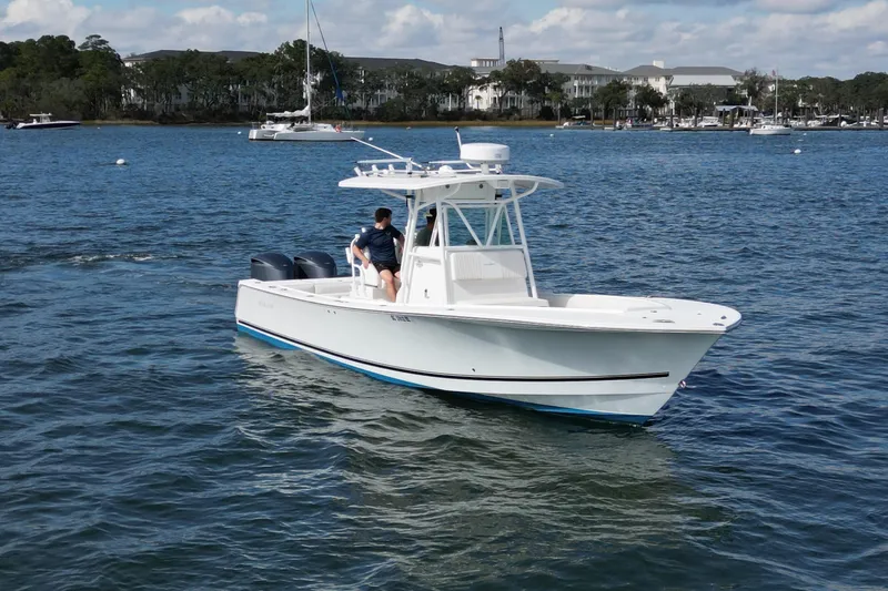  Yacht Photos Pics 2008 Regulator 32 Forward Seating boat cruising on a calm lake with scenic background.