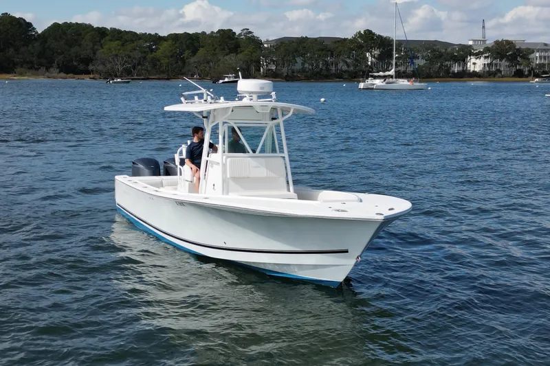  Yacht Photos Pics 2008 Regulator 32 Forward Seating boat on calm water, with scenic shoreline background.