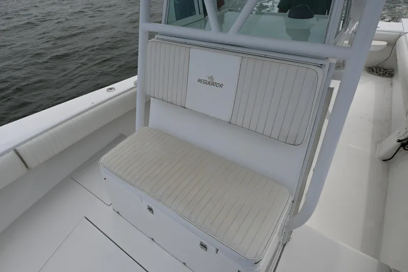  Yacht Photos Pics 2008 Regulator 32 Forward Seating boat with cushioned bench, white interior, and ocean backdrop.