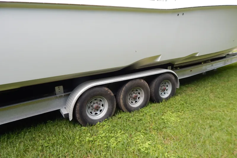  Yacht Photos Pics 2013 Invincible 42 Open Fisherman boat on a triple-axle trailer, parked on grass.