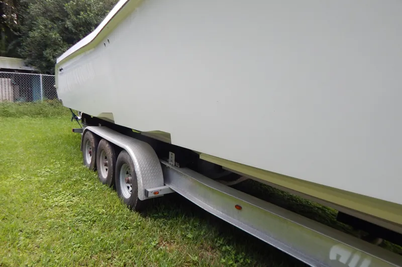  Yacht Photos Pics 2013 Invincible 42 Open Fisherman boat on a trailer, parked on grass.