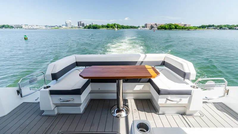 Belle Yacht Photos Pics 2018 Cruisers Yachts 50 Cantius deck with seating and table, cruising on a sunny day.