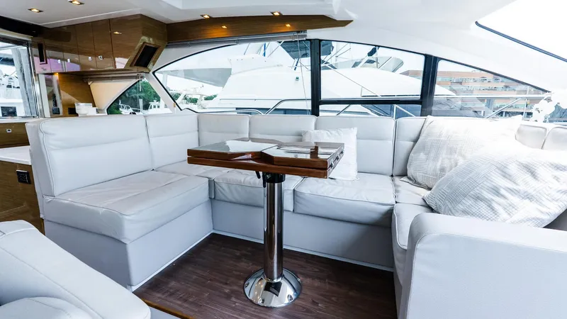 Belle Yacht Photos Pics Luxurious interior of 2018 Cruisers Yachts 50 Cantius with white seating and wooden accents.