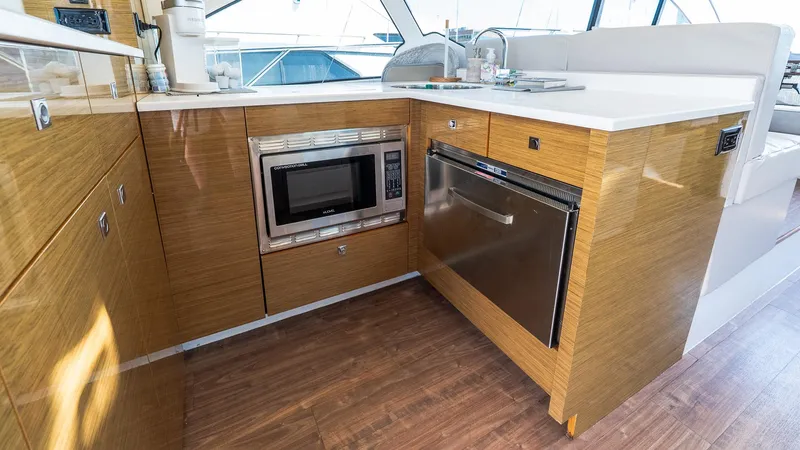 Belle Yacht Photos Pics Modern kitchen area in 2018 Cruisers Yachts 50 Cantius with microwave and sleek cabinetry.