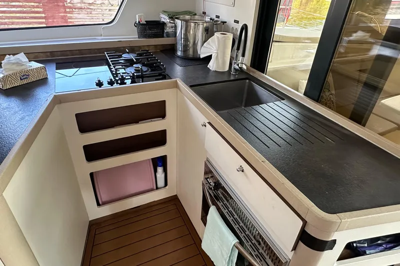 Bolubo Yacht Photos Pics Modern kitchen in a 2019 Lagoon 42 yacht with stove, sink, and storage.