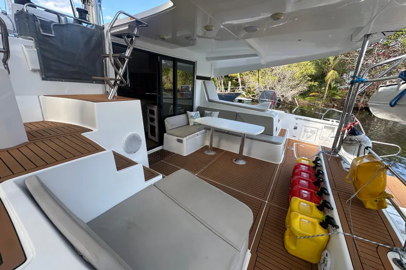 Bolubo Yacht Photos Pics 2019 Lagoon 42 catamaran deck with seating, table, and fuel containers.