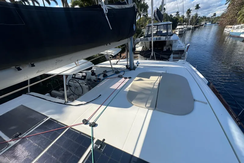 Bolubo Yacht Photos Pics 2019 Lagoon 42 catamaran on a serene waterway, featuring solar panels and a spacious deck.