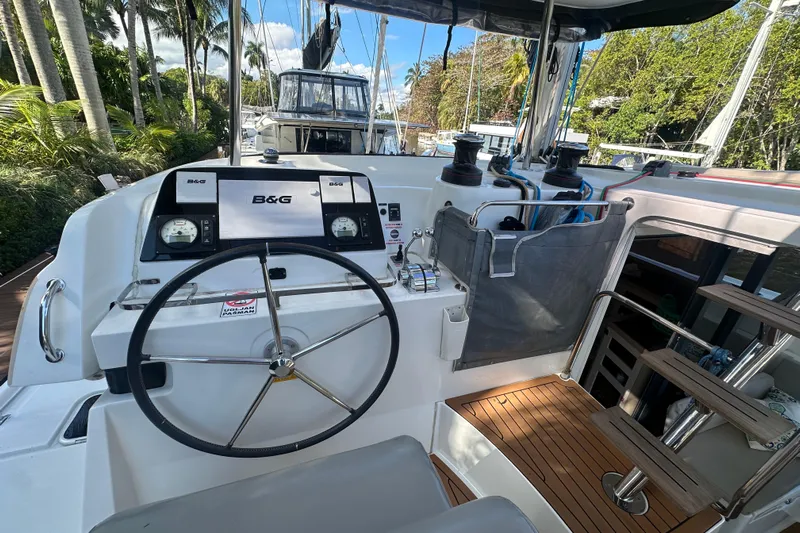 Bolubo Yacht Photos Pics Helm of 2019 Lagoon 42 catamaran with B&G navigation system, docked near lush greenery.