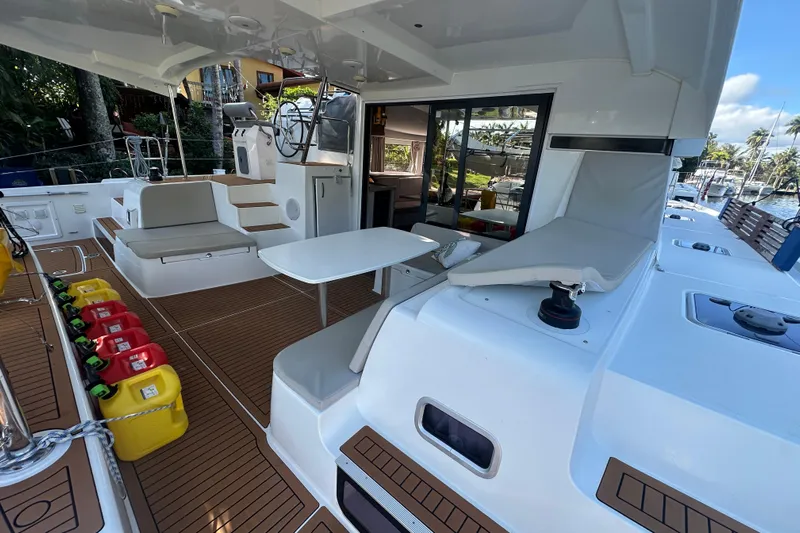 Bolubo Yacht Photos Pics 2019 Lagoon 42 catamaran deck with seating, table, and fuel containers.