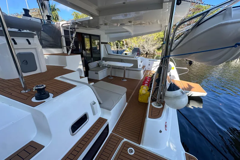 Bolubo Yacht Photos Pics 2019 Lagoon 42 catamaran deck with seating, table, and water view.