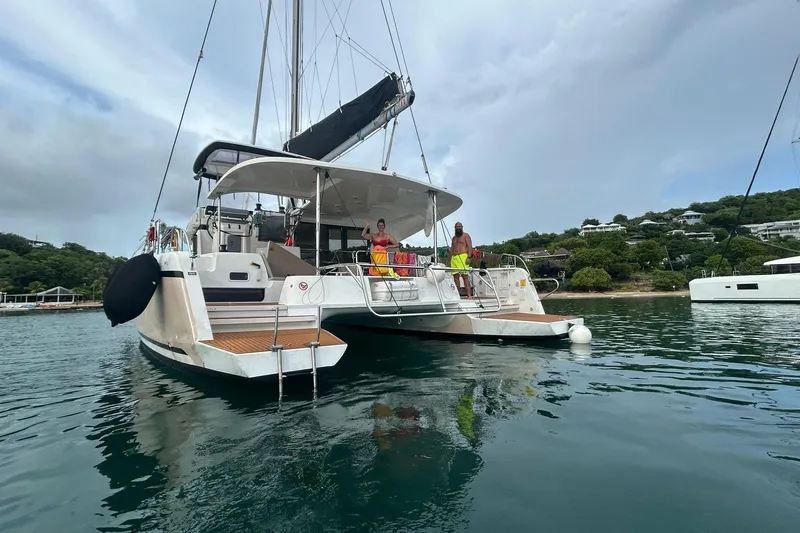 Bolubo Yacht Photos Pics 2019 Lagoon 42 catamaran anchored in scenic bay with people on deck.