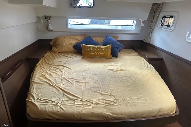 Bolubo Yacht Photos Pics Cozy cabin bedroom in 2019 Lagoon 42 catamaran with yellow bedding and decorative pillows.