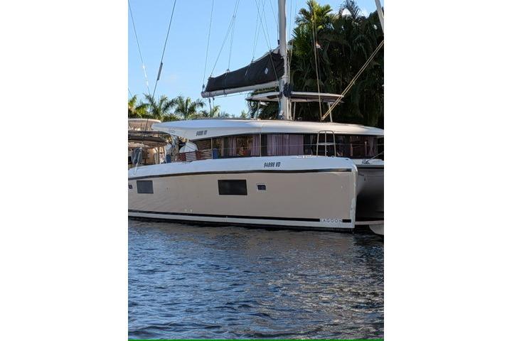 2019 Lagoon 42 catamaran docked by palm trees, featuring sleek design and modern amenities.