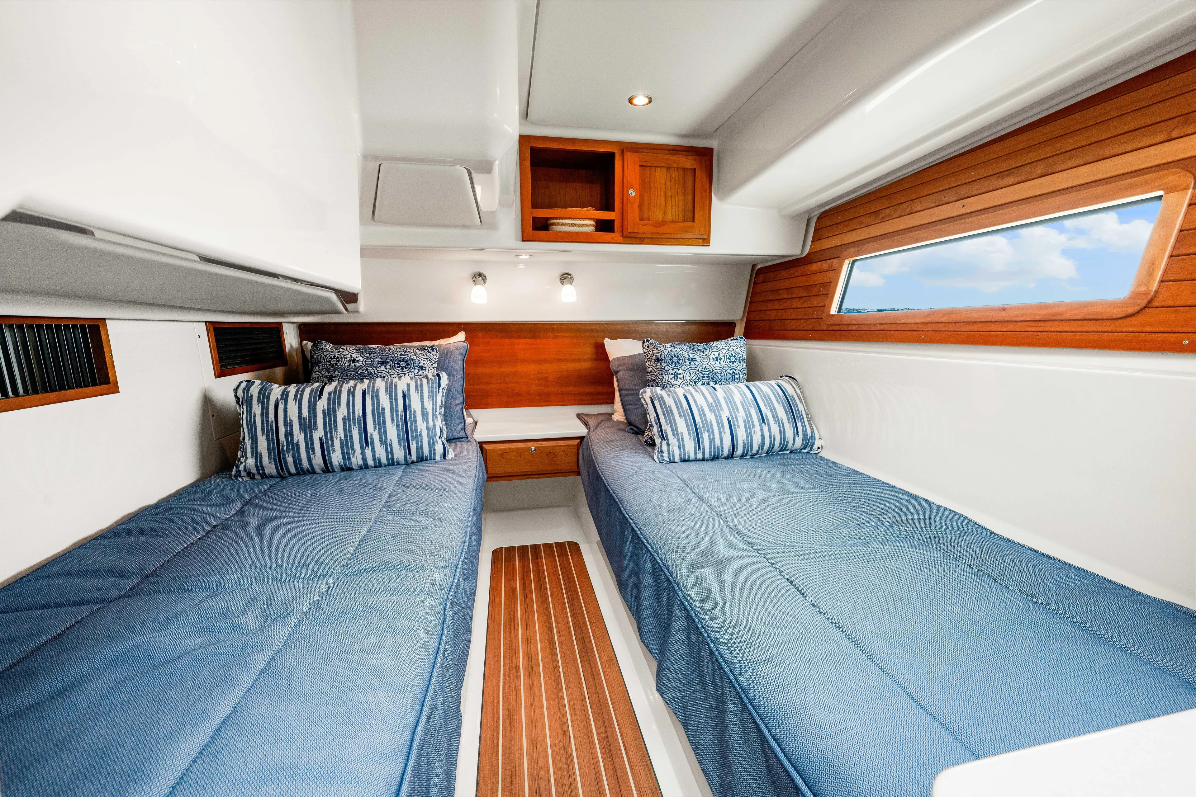  Yacht Photos Pics 2024 Back Cove 39O cabin with twin beds, blue bedding, and wooden accents.