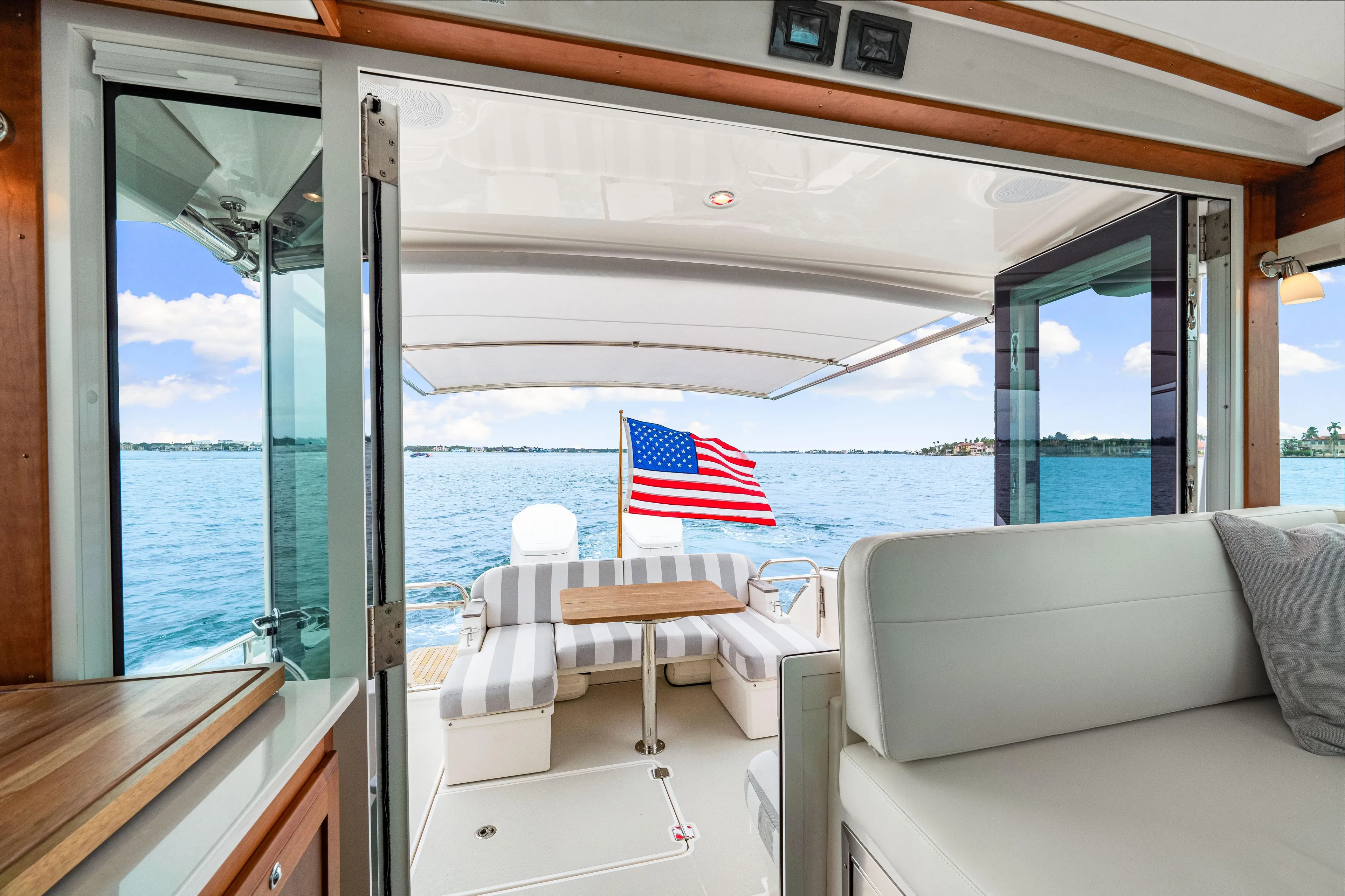  Yacht Photos Pics 2024 Back Cove 39O yacht interior with American flag, ocean view, and seating area.