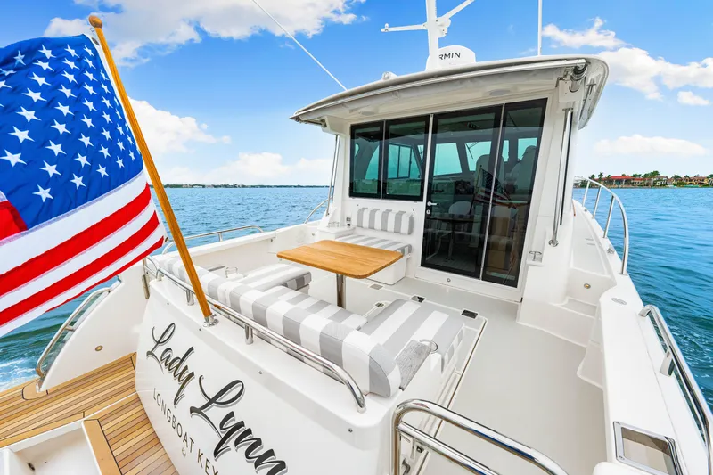  Yacht Photos Pics 2024 Back Cove 39O yacht with American flag, spacious deck, and elegant seating.