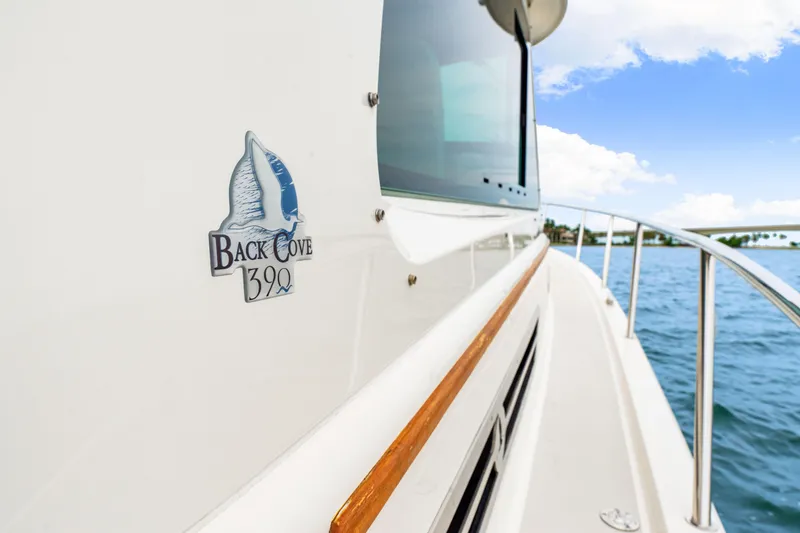  Yacht Photos Pics 2024 Back Cove 39O boat side view with logo, cruising on water.