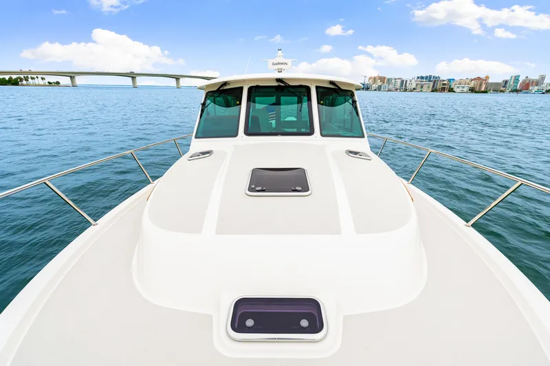  Yacht Photos Pics 2024 Back Cove 39O boat on water, cityscape and bridge in background.