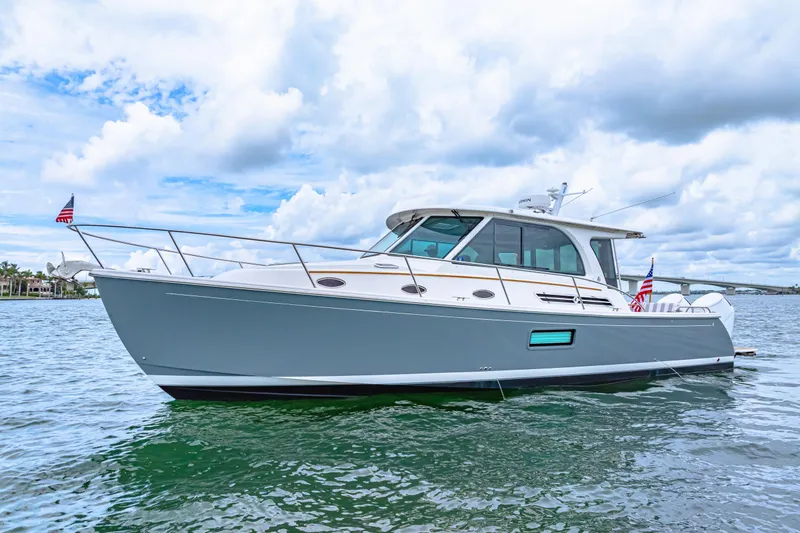  Yacht Photos Pics 2024 Back Cove 39O boat on water, sleek design, cloudy sky background.