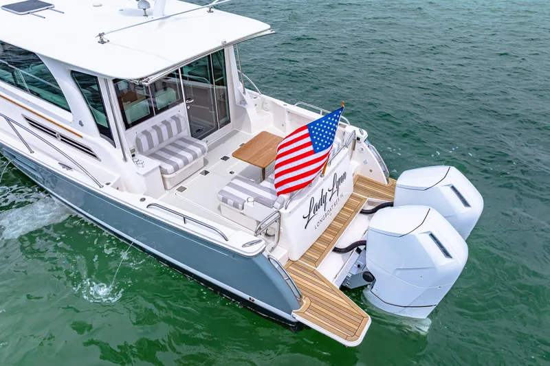  Yacht Photos Pics 2024 Back Cove 39O yacht with American flag, spacious deck, and twin outboard engines.