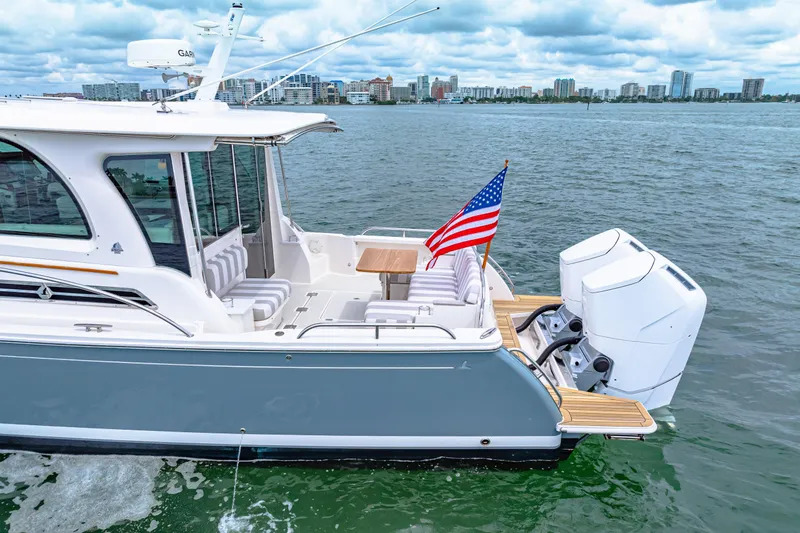 Yacht Photos Pics 2024 Back Cove 39O yacht with American flag, docked on calm waters.