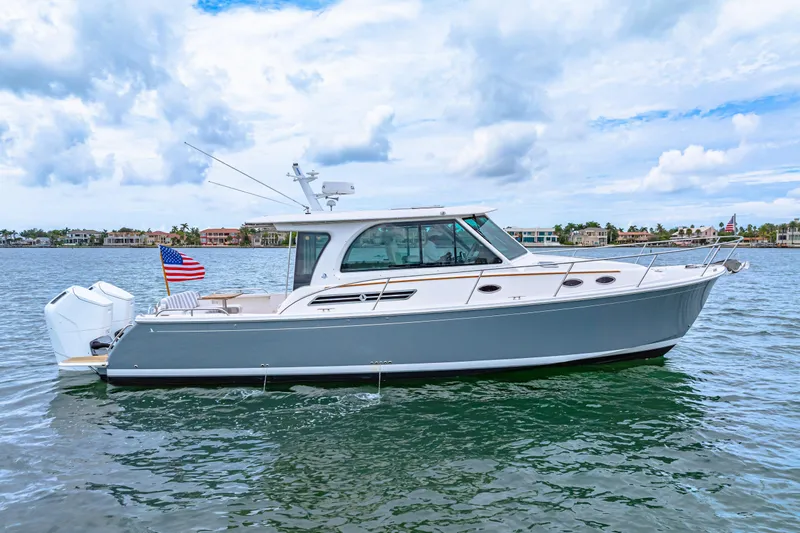  Yacht Photos Pics 2024 Back Cove 39O boat on water, American flag, clear sky background.