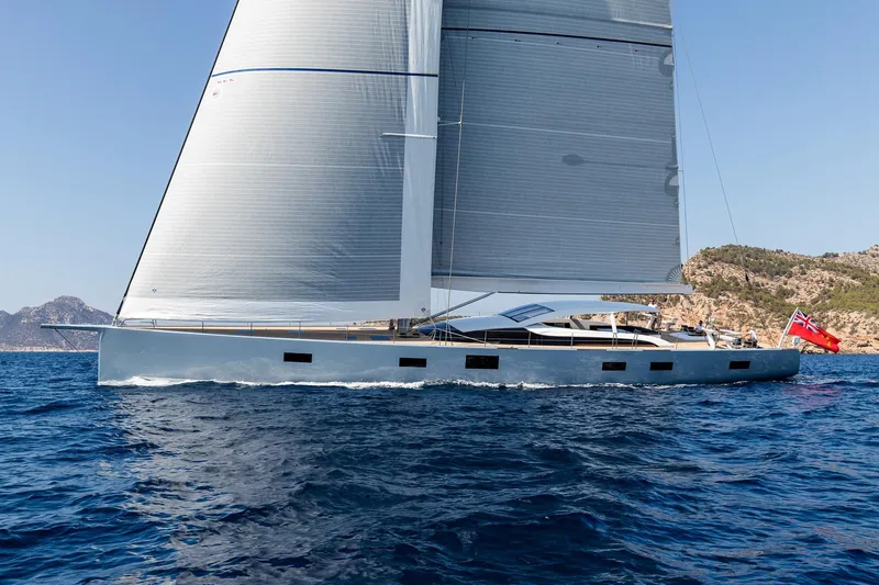 Liara Yacht Photos Pics Luxurious 2019 Baltic Custom 112 yacht sailing near rocky coastline under clear blue skies.
