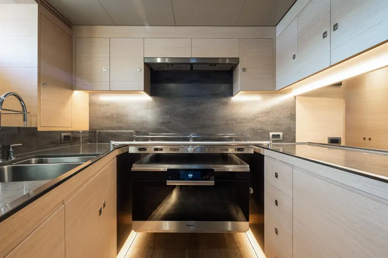 Liara Yacht Photos Pics Modern kitchen interior on Baltic Custom 112 yacht, 2019 model, featuring sleek cabinetry and stainless steel appliances.
