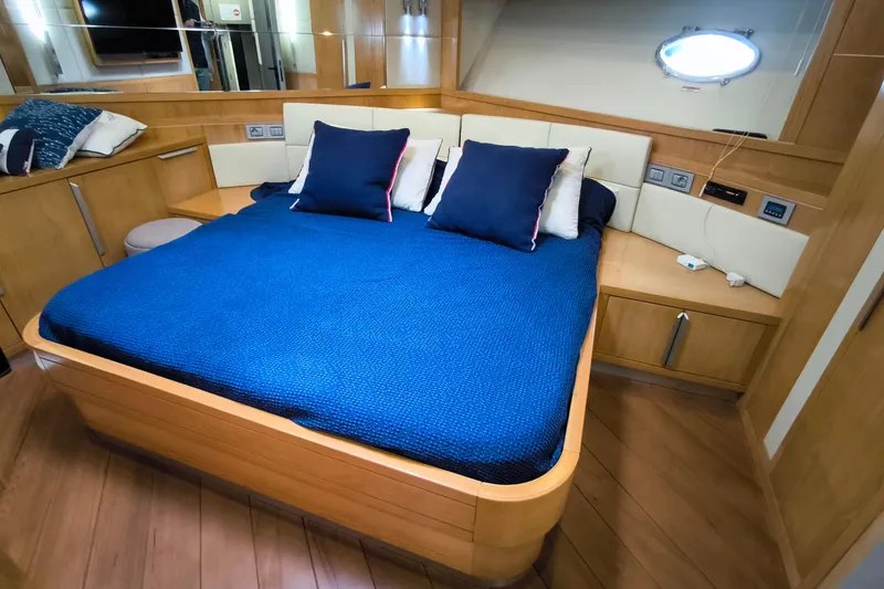 Mister Corn Yacht Photos Pics Luxurious bedroom interior of 2010 Rodman Muse 74 yacht with blue bedding and wooden accents.