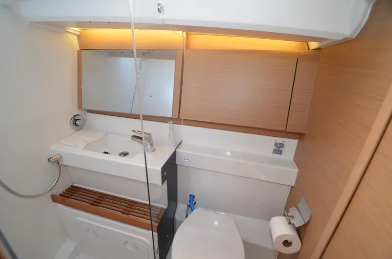 Her Intentions Yacht Photos Pics Modern bathroom in 2021 Jeanneau Sun Odyssey 440 yacht, featuring sleek design and wooden accents.