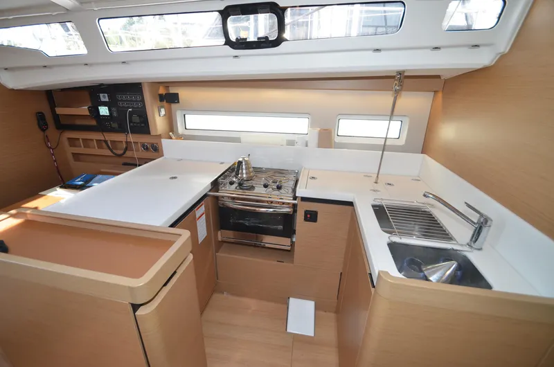 Her Intentions Yacht Photos Pics Modern kitchen interior of 2021 Jeanneau Sun Odyssey 440 yacht, featuring stove and sink.