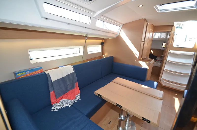 Her Intentions Yacht Photos Pics Interior of 2021 Jeanneau Sun Odyssey 440 sailboat with blue seating and wooden table.