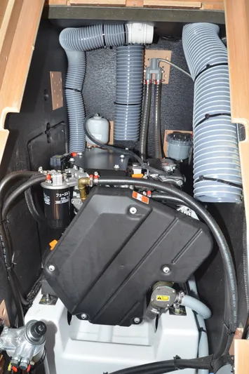 Her Intentions Yacht Photos Pics Engine compartment of 2021 Jeanneau Sun Odyssey 440 sailboat, featuring hoses and mechanical components.